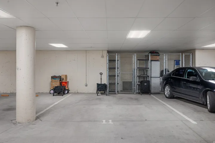 Dedicated parking space featuring concrete flooring, a support column, and overhead lighting