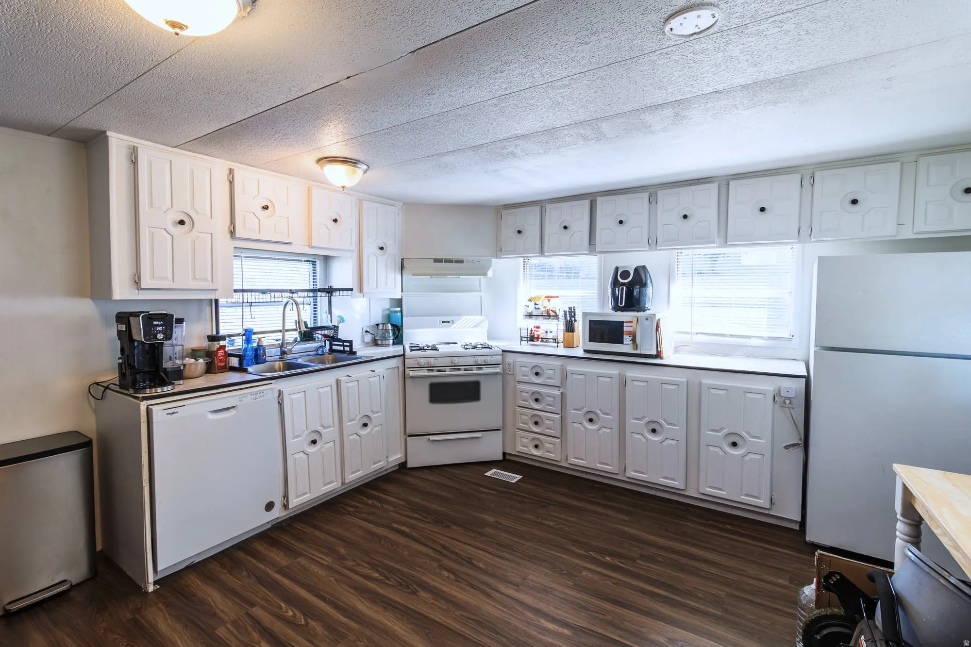 Kitchen featuring wood-finish flooring and white cabinetry