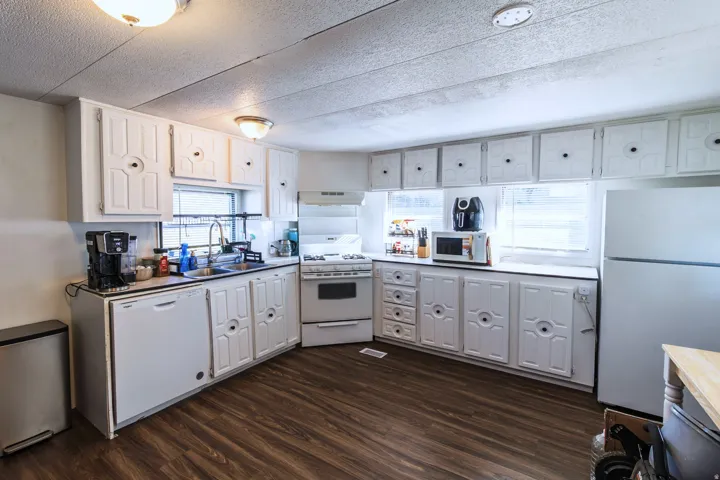 Kitchen featuring wood-finish flooring and white cabinetry