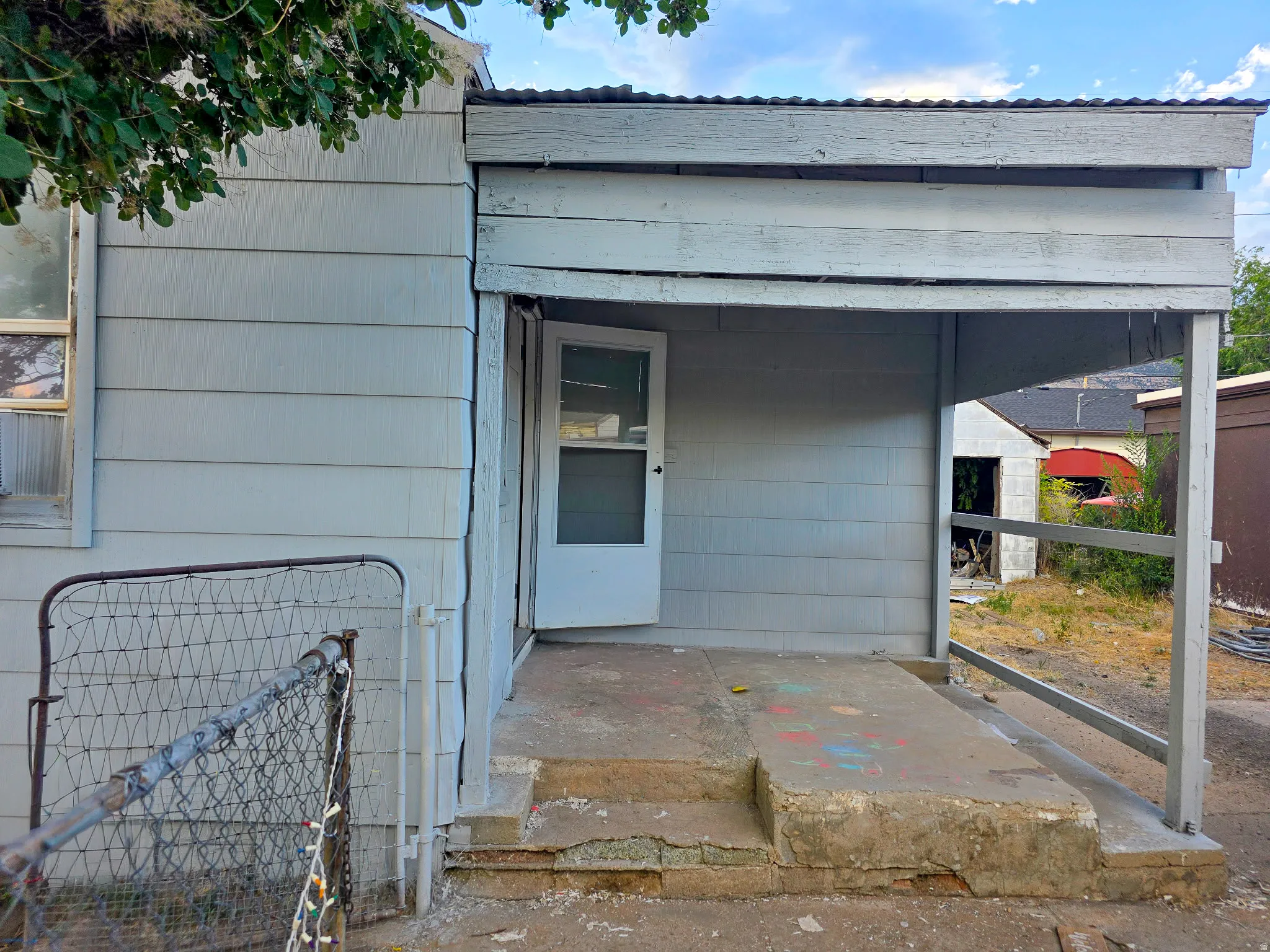 Covered entry porch featuring a screen door and concrete steps