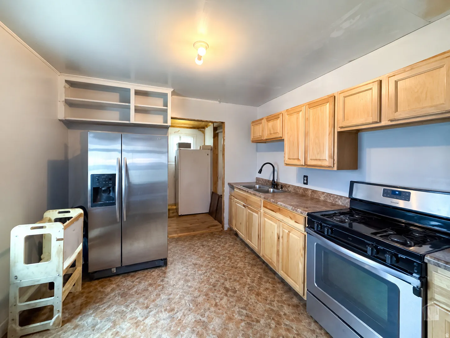 Kitchen featuring wood cabinetry, stainless steel appliances, and a black gooseneck faucet
