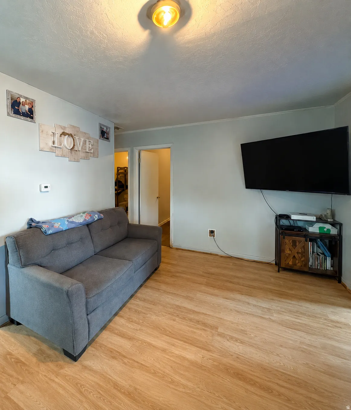 Light-toned wood-finish flooring complements the neutral wall color in this interior space