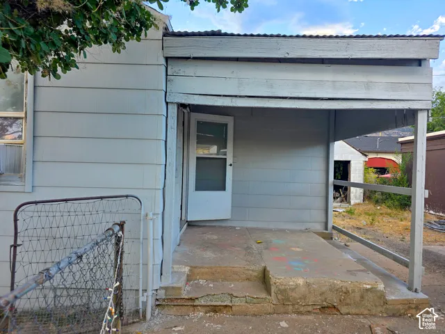 Covered entry porch featuring a screen door and concrete steps