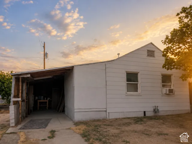 Property exterior featuring white horizontal siding and an attached carport with a concrete floor