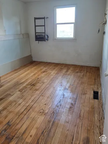 Wood-finish flooring with a window offering natural light