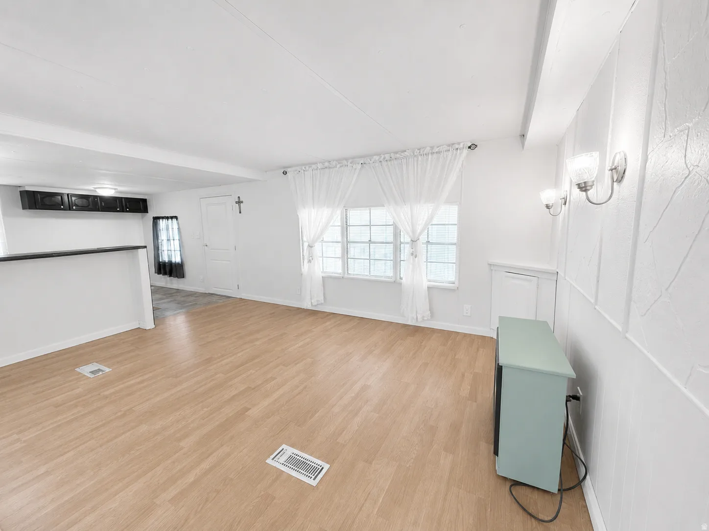 Spacious main living area with abundant natural light, neutral finishes, and open flow toward the kitchen.