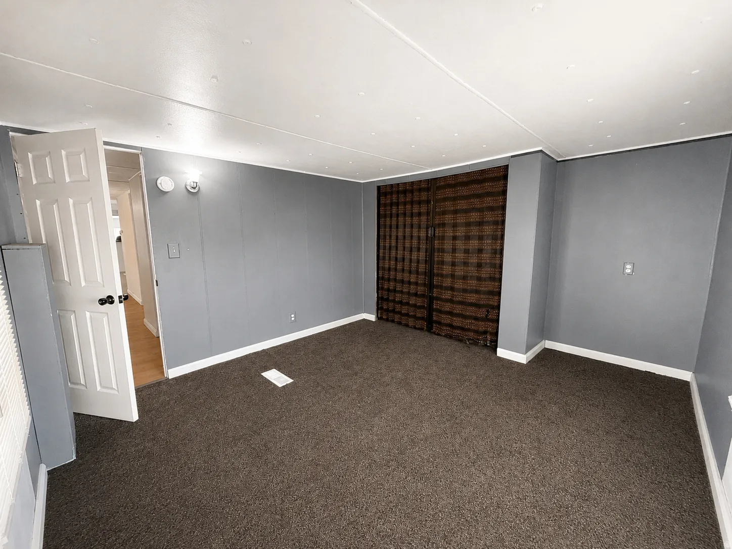 Additional bedroom angle with closet area, dark carpet, and easy access to the hallway.