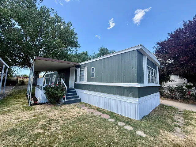 Exterior view showcasing the covered porch, side yard, and inviting entryway with room for outdoor seating or personal touches.