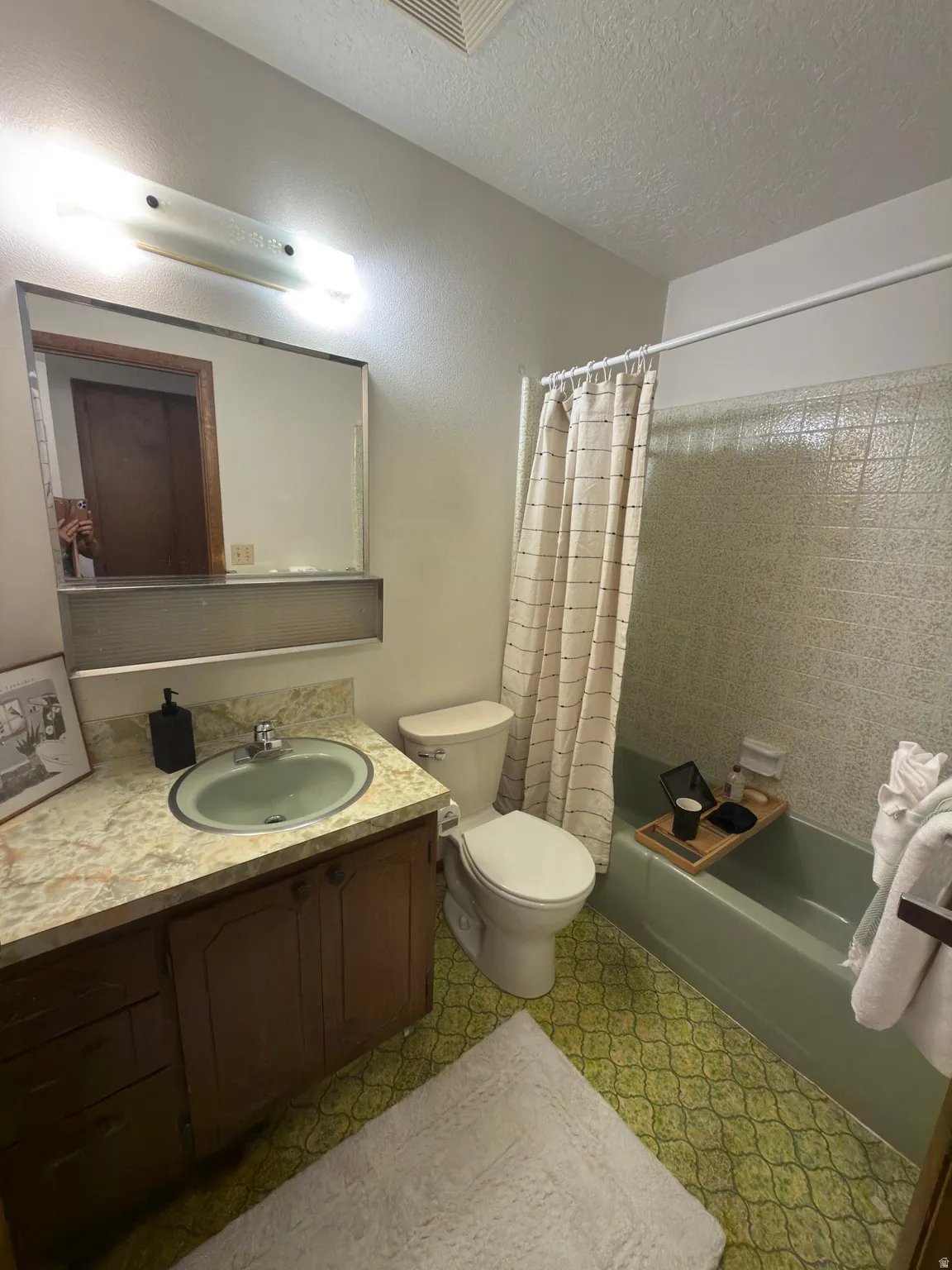 Bathroom featuring a vanity with a light-colored countertop, an integrated sink, and wood cabinetry