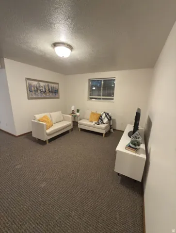 Carpeted interior space featuring white walls and a window with blinds