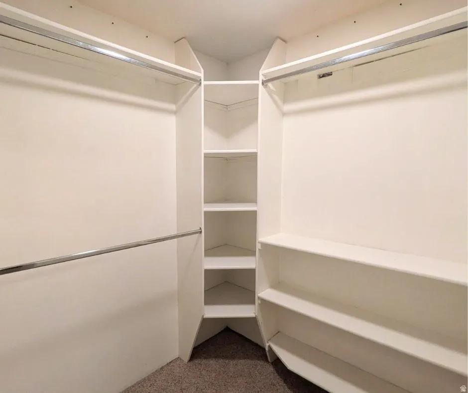 Walk-in closet featuring built-in shelving, multiple hanging rods, and corner storage