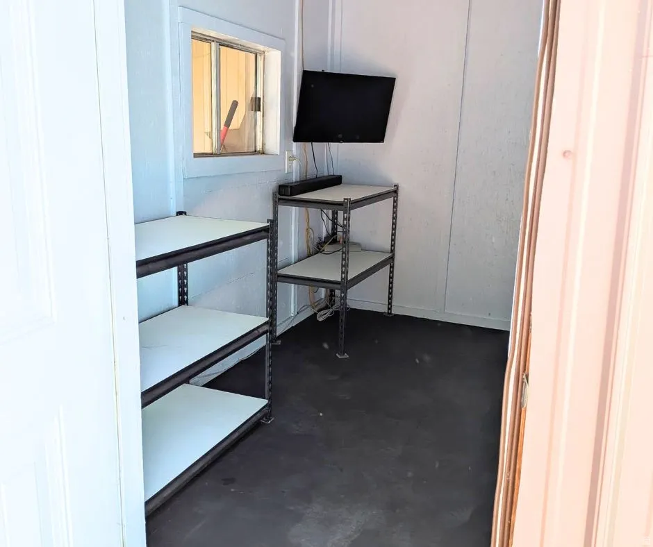 Interior space featuring white paneled walls and dark flooring
