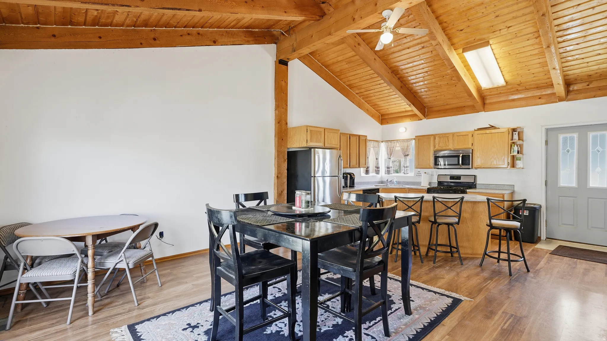Open-concept kitchen and dining area with vaulted wood-plank ceilings