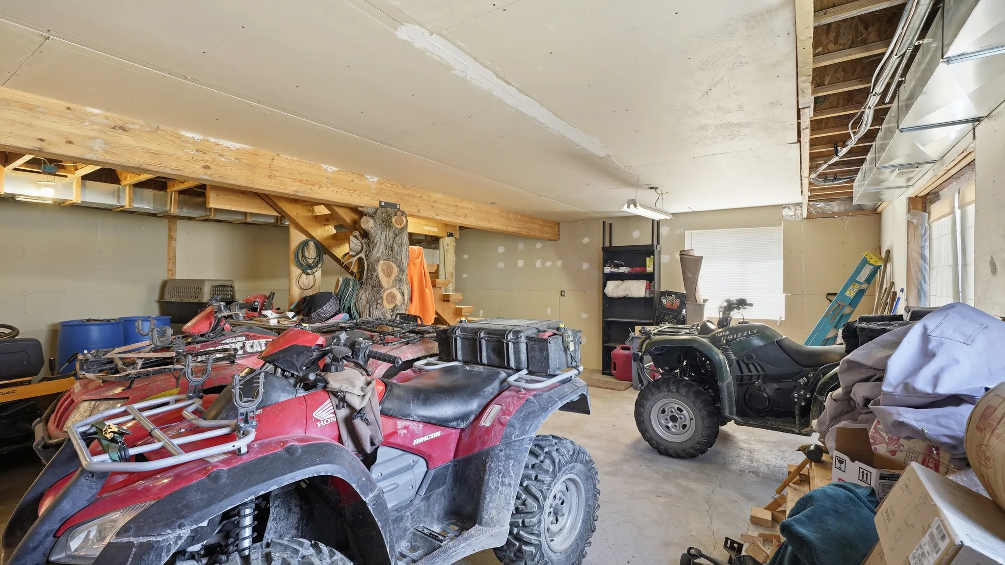 Spacious garage with exposed wooden beams, concrete flooring, recessed lighting, and ample storage space