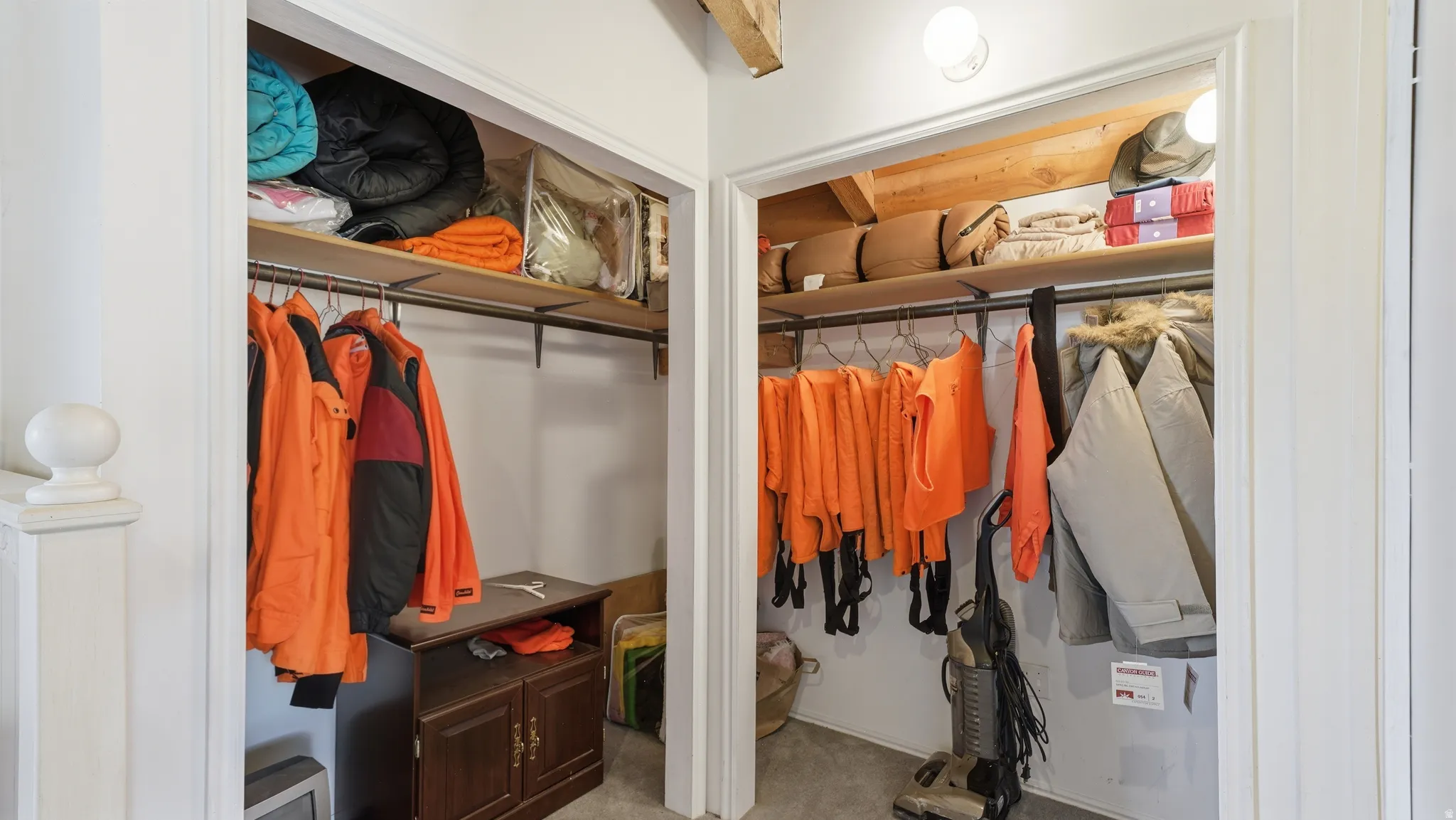 Dual closet spaces featuring upper shelving, integrated clothing rods, and overhead lighting