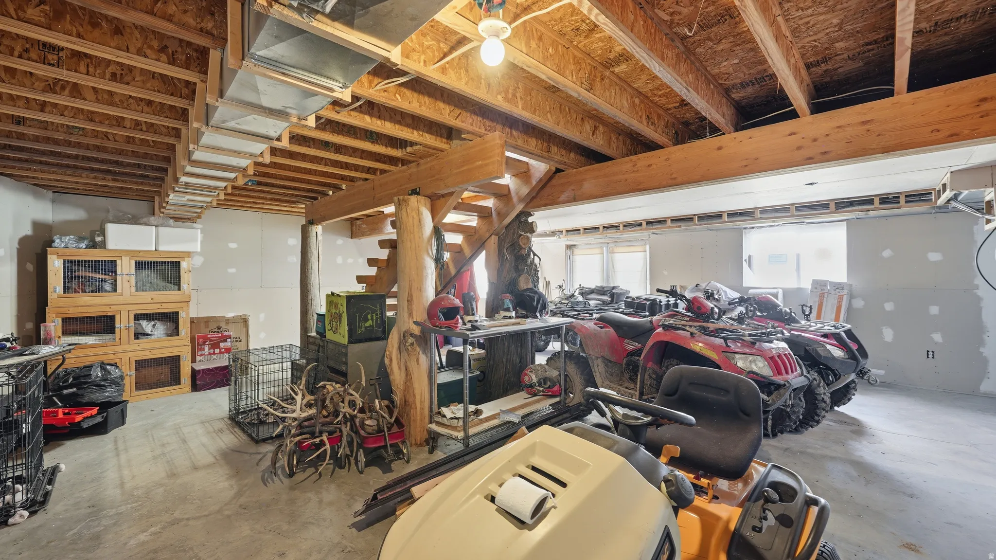 Spacious unfinished basement featuring exposed wood joists and a concrete floor