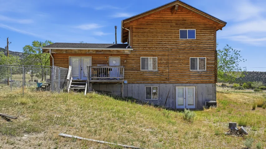 Log-style exterior with a wood deck and fenced area