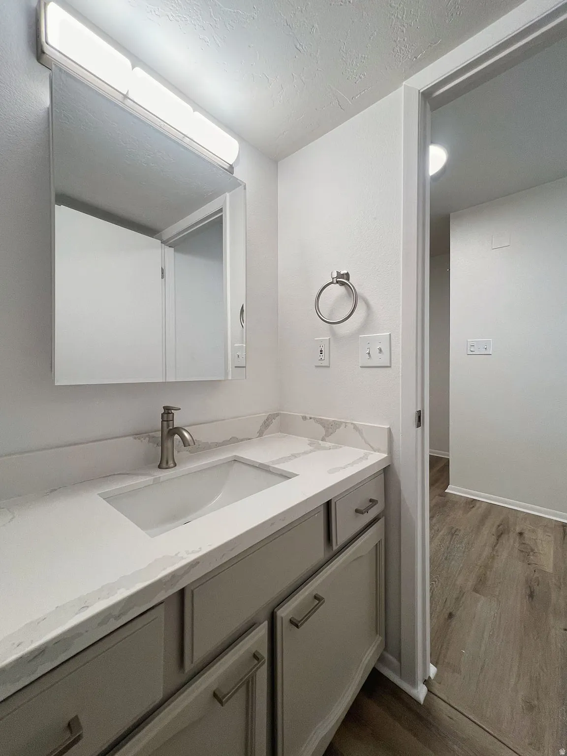 Vanity featuring a built-in rectangular sink, stone-finish countertop, and brushed nickel faucet