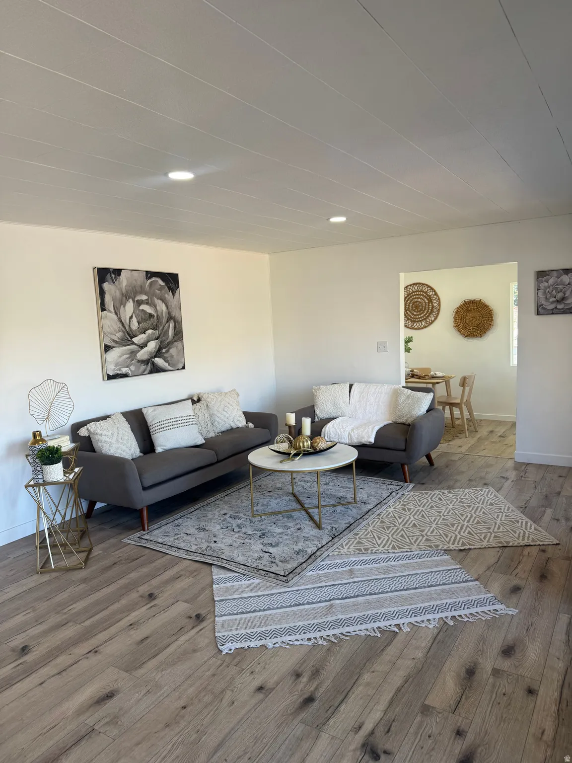 Living area featuring wood-finish flooring, recessed lighting, and an open archway to an additional room