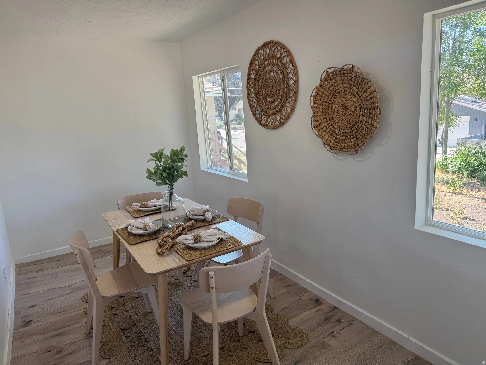 Bright dining area featuring light wood-finish flooring and multiple windows