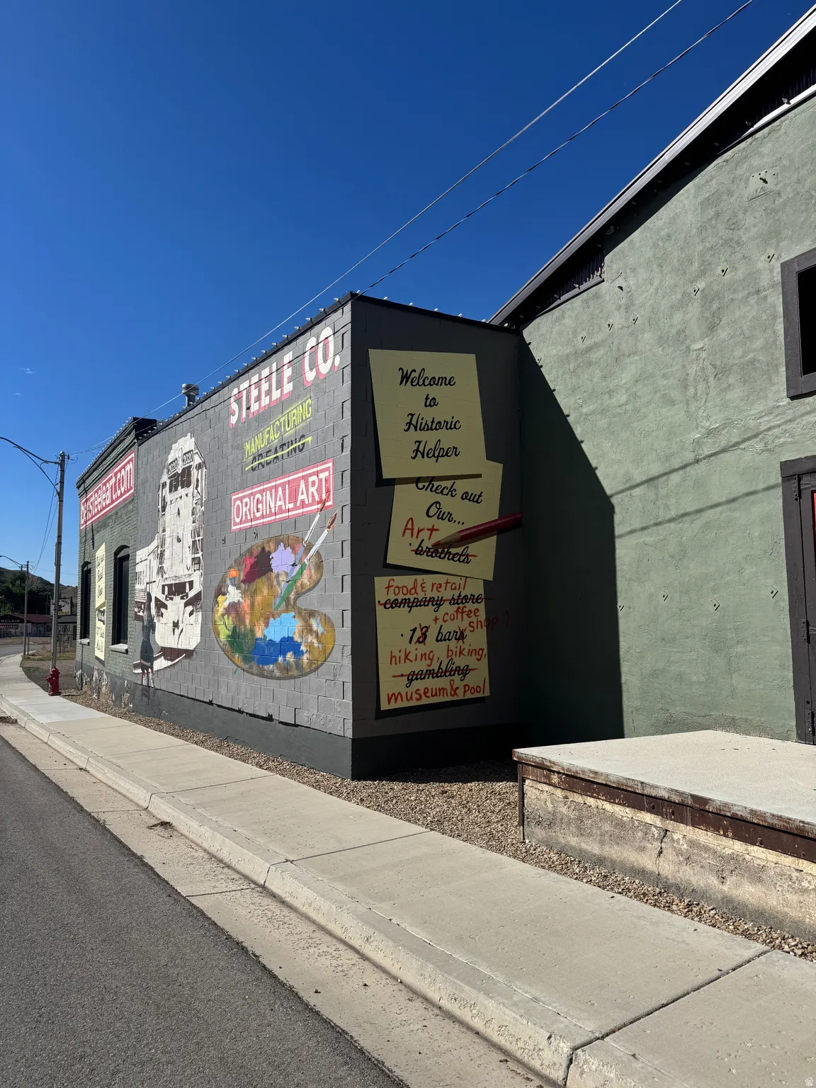 Commercial building exterior featuring a painted mural, concrete block facade, and painted stucco finish