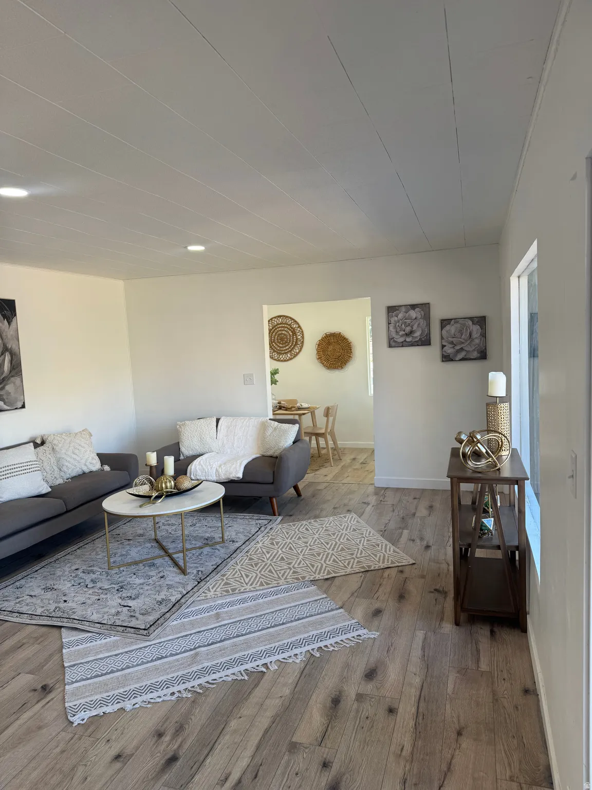 Spacious living area featuring wood-finish flooring, recessed lighting, and a neutral color palette