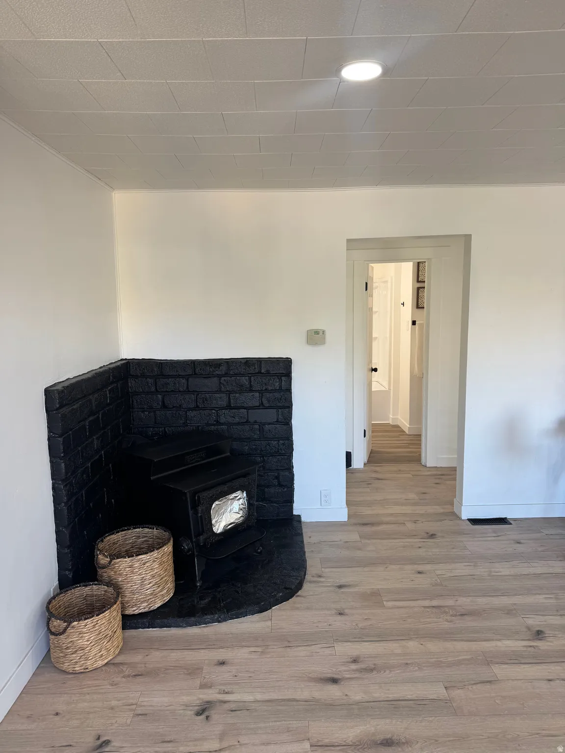 Corner brick fireplace with a black painted finish and an inserted wood-burning stove