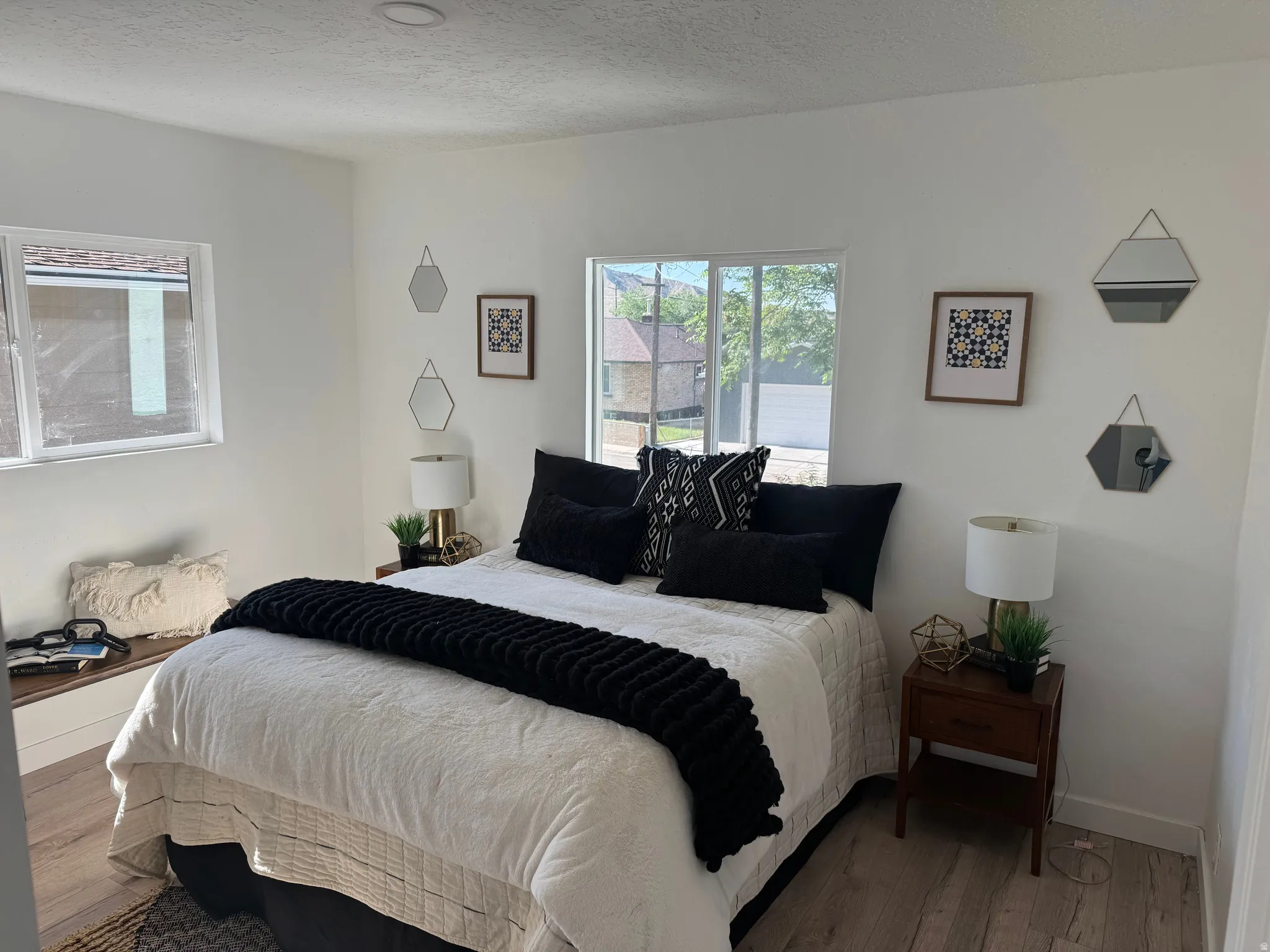 Bright bedroom featuring light wood-finish flooring and white walls