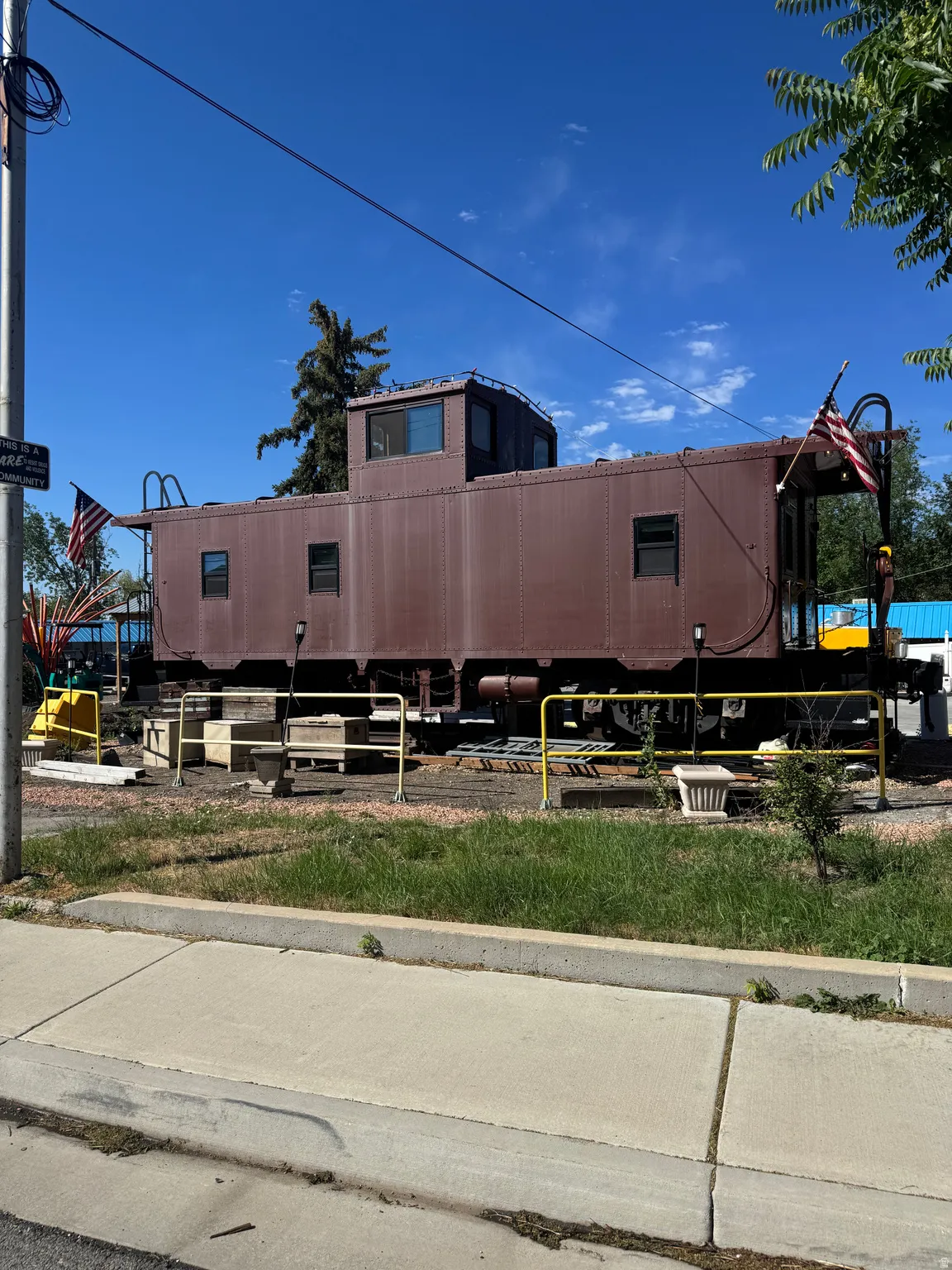 Historic caboose structure featuring a raised cupola, multiple window openings, and an exterior ladder