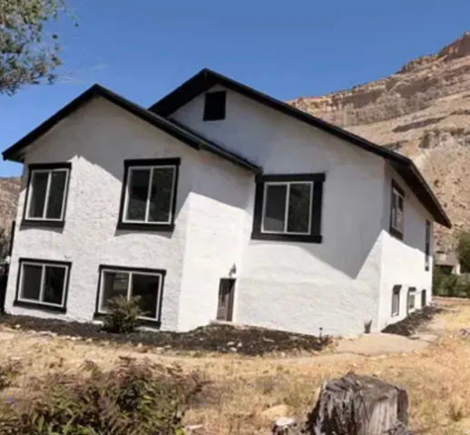 White stucco exterior with contrasting dark trim and dark-framed windows
