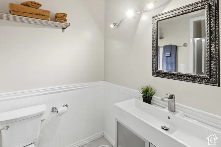 Bathroom featuring a rectangular vessel sink with a single-handle chrome faucet, an ornate framed mirror, and a wall-mounted light fixture