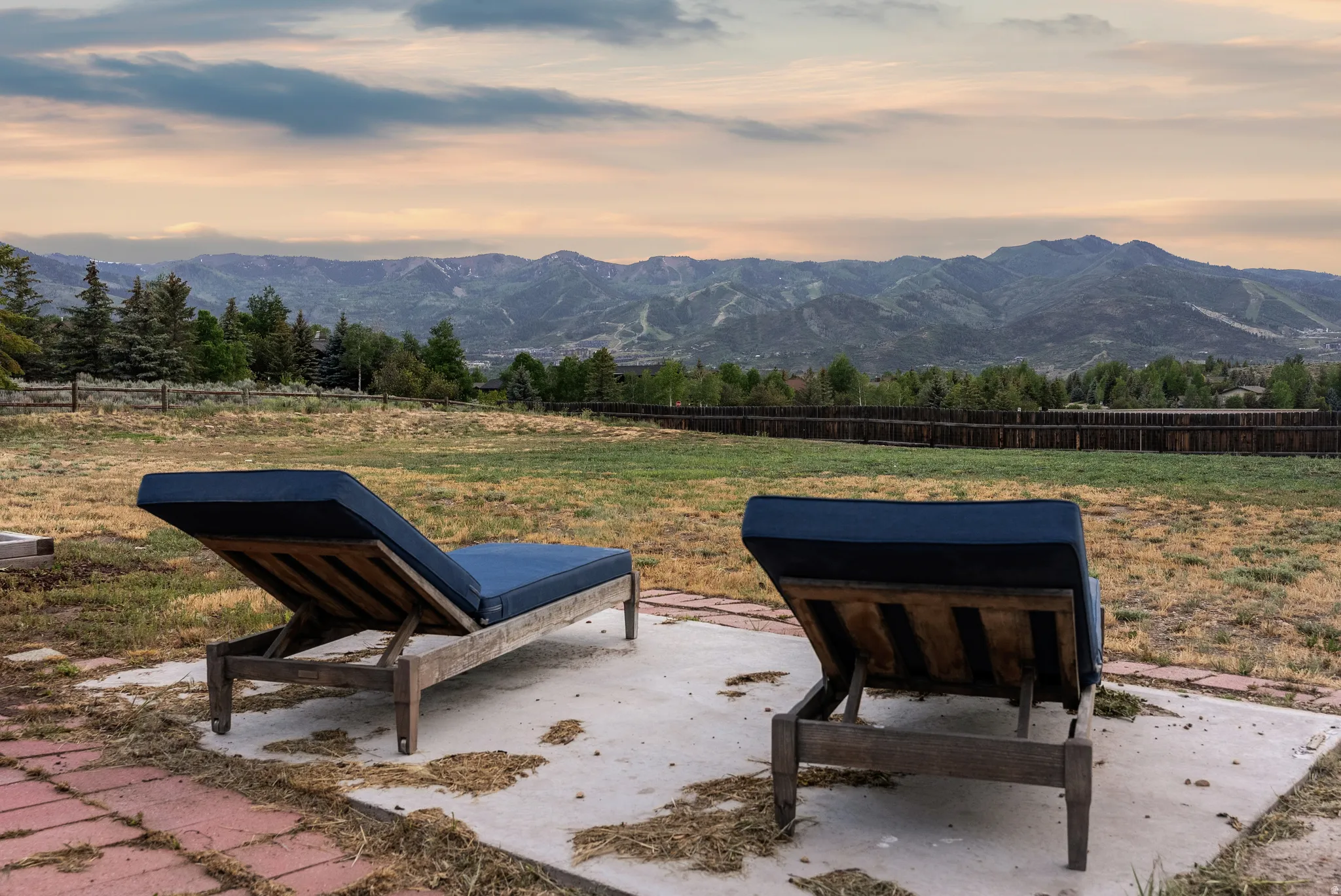 Expansive outdoor space featuring a large lawn area and a mountain backdrop