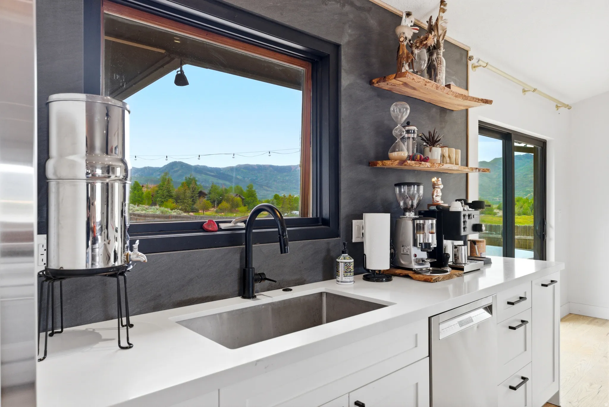 Kitchen area featuring white cabinetry, a stainless steel undermount sink with a matte black faucet, and a stainless steel dishwasher