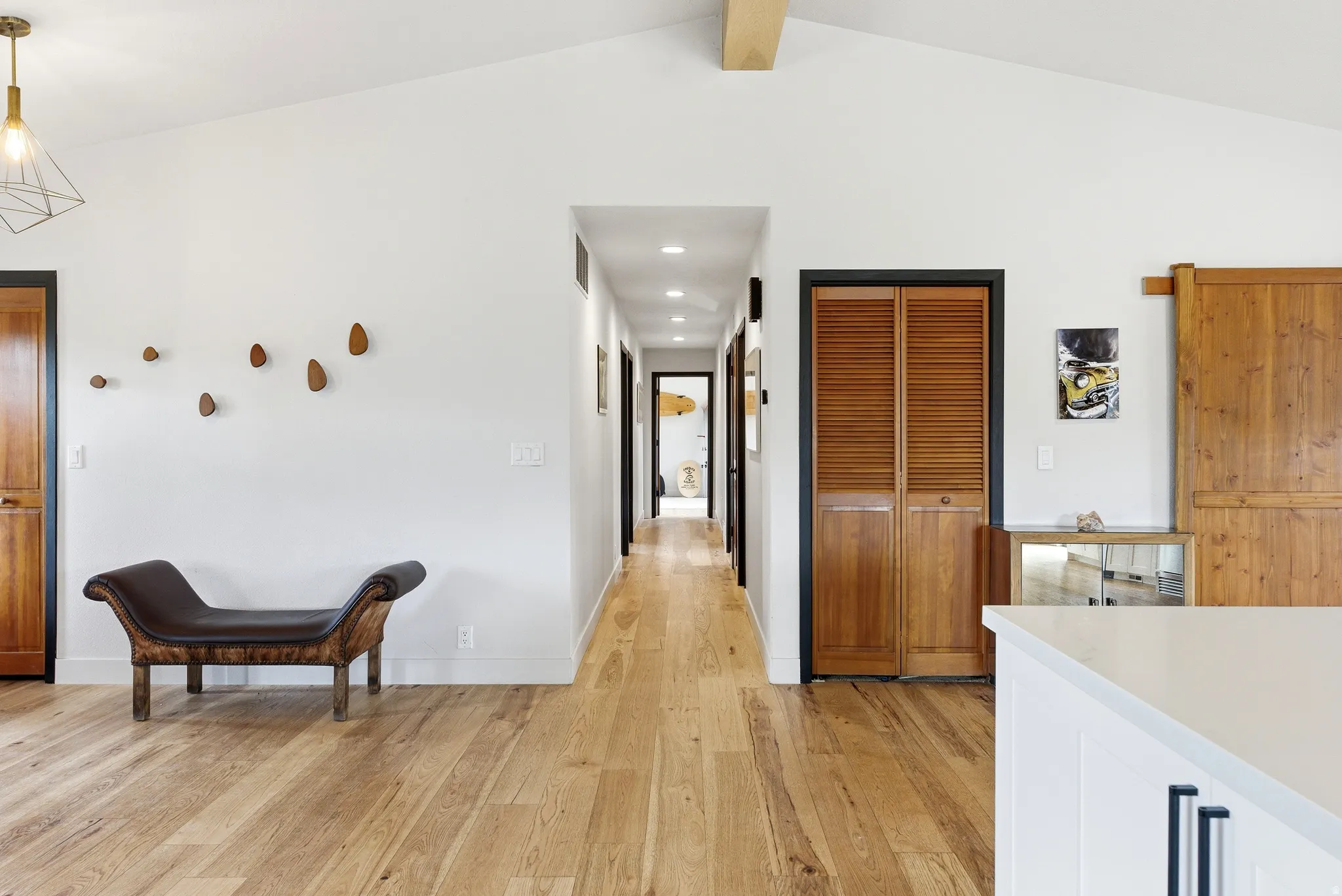 Vaulted ceiling with an exposed wood beam, complemented by light wood-finish flooring