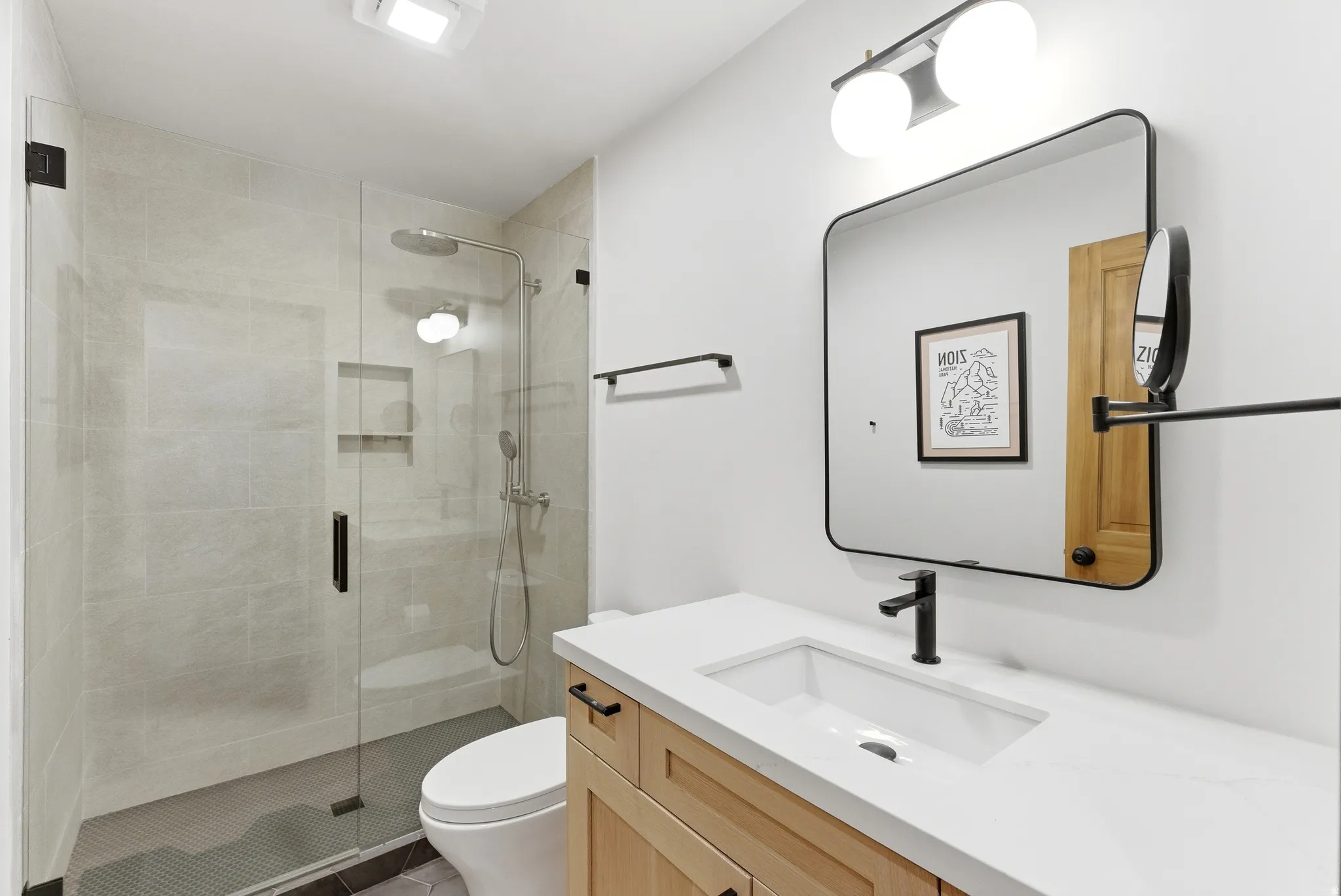 Modern bathroom featuring a glass-enclosed shower with tiled walls and a built-in niche