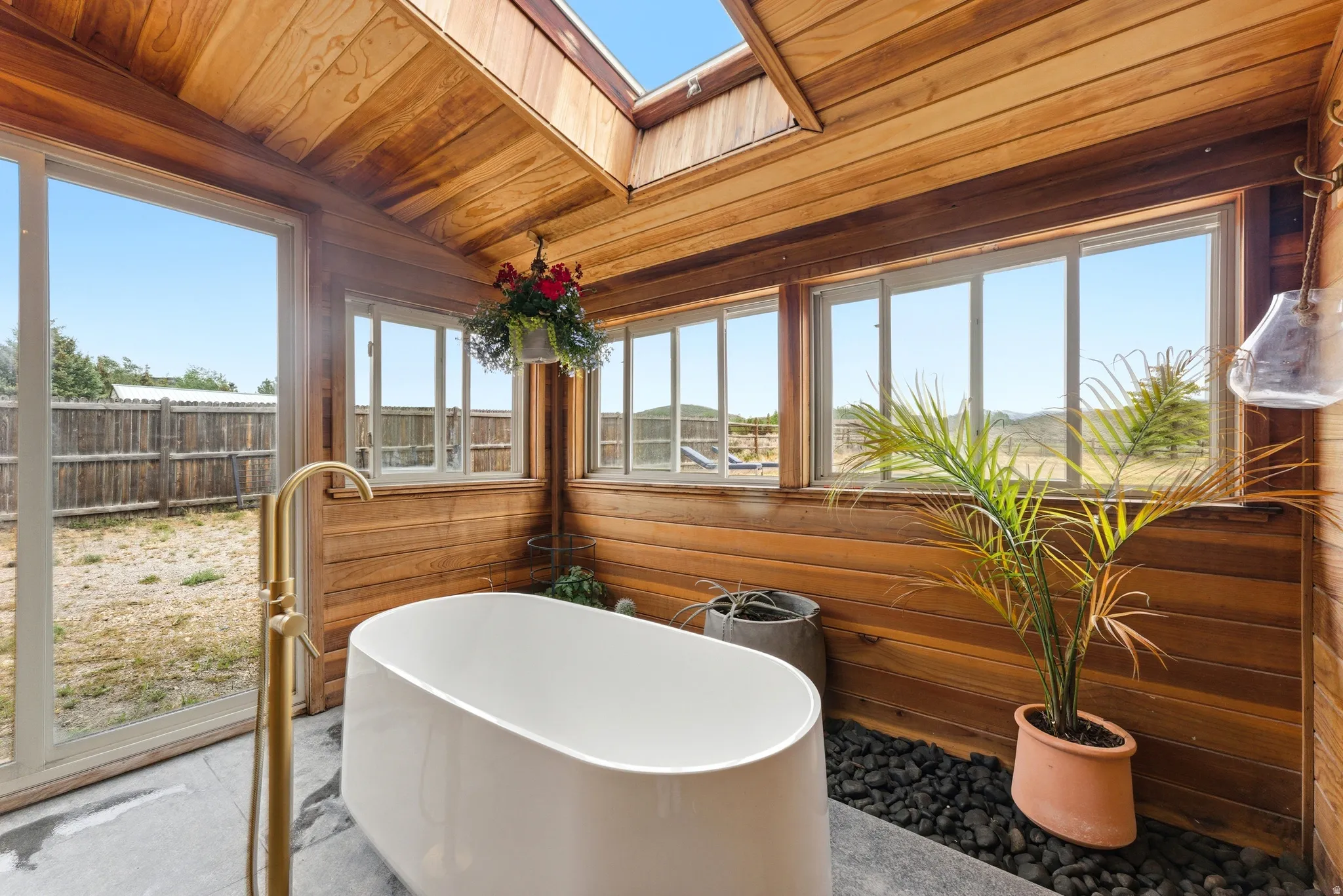 Freestanding soaking tub with a floor-mounted golden-finish faucet