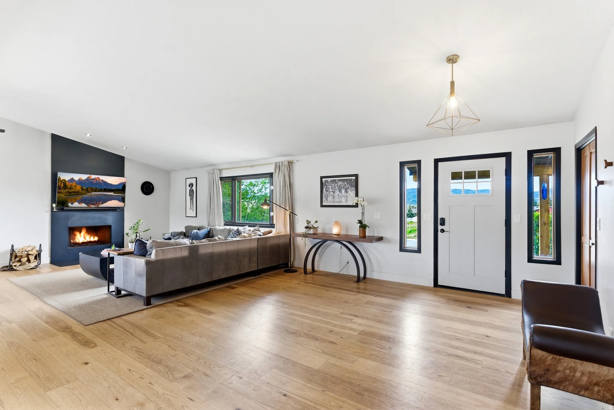 Light wood-finish flooring throughout, complemented by a modern fireplace with a dark surround