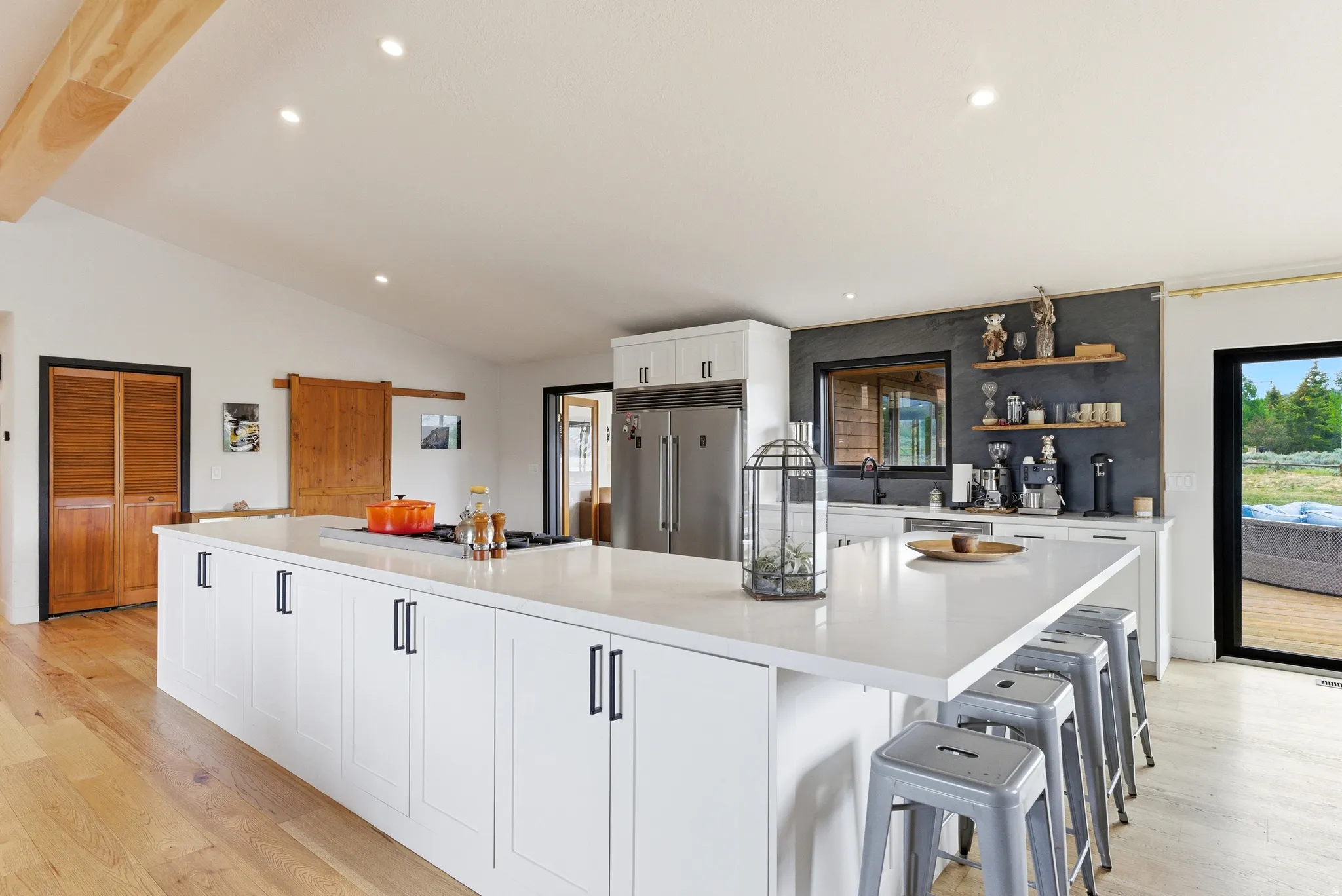 Open-concept kitchen featuring an expansive central island with a solid surface countertop, integrated cooktop, and casual dining space