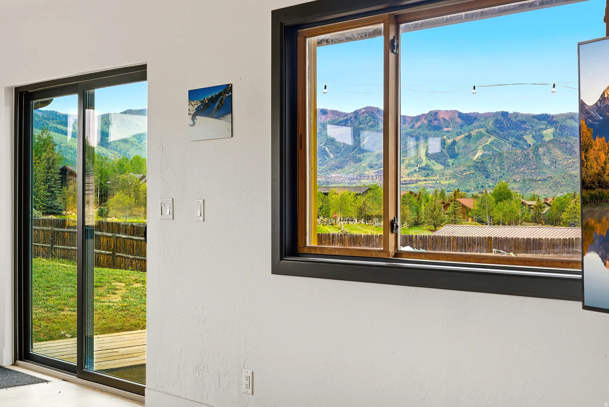 Expansive mountain scenery framed by a large wood-framed window with a black trim