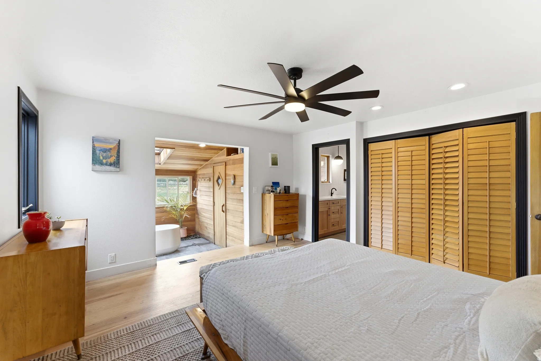 Bedroom featuring light wood-finish flooring, a contemporary ceiling fan, recessed lighting, and louvered bifold closet doors