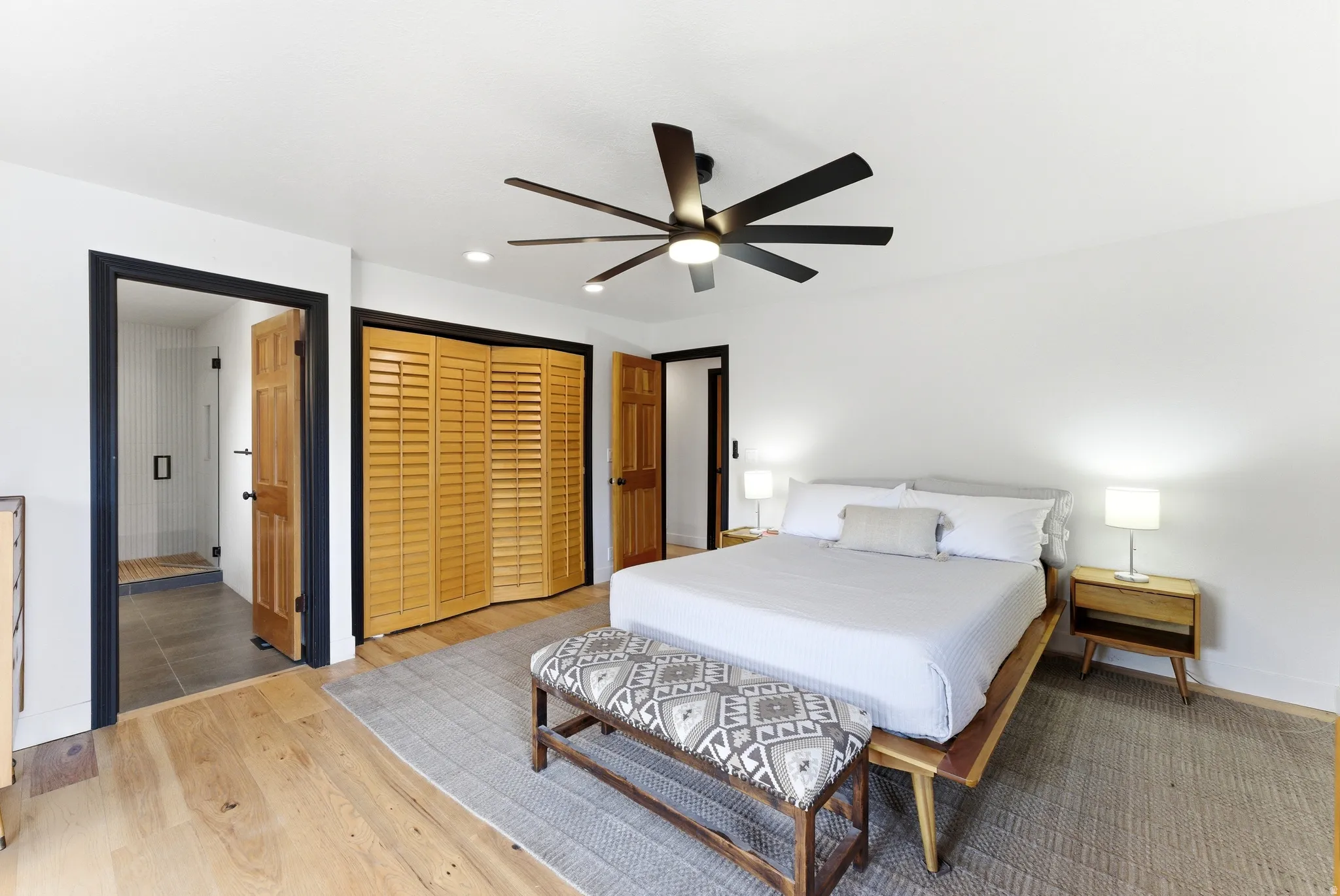 Spacious room featuring wood-finish flooring, a contemporary ceiling fan, and recessed lighting