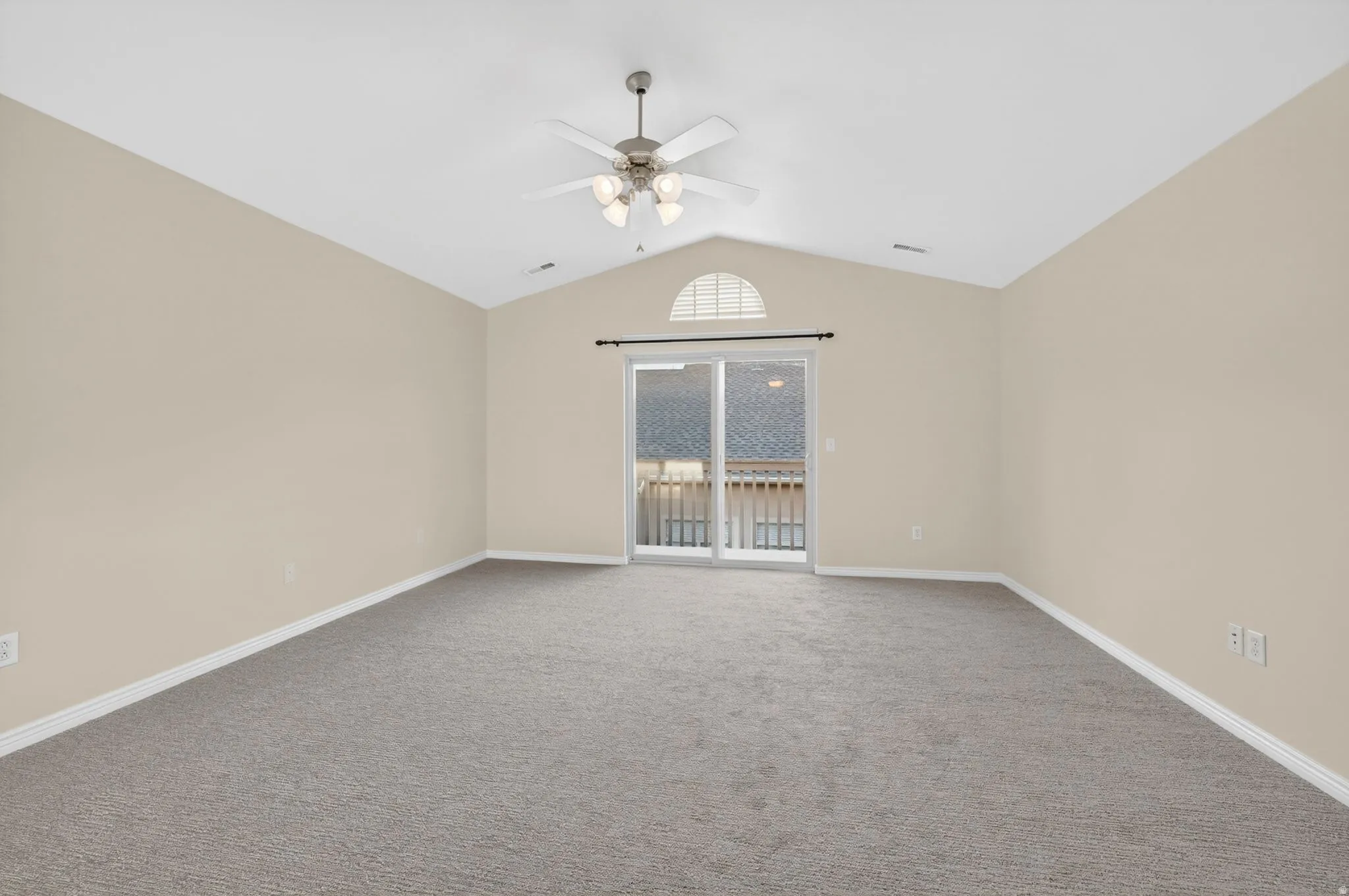 Spacious room featuring vaulted ceilings, a ceiling fan with integrated lighting, and neutral-toned carpeting