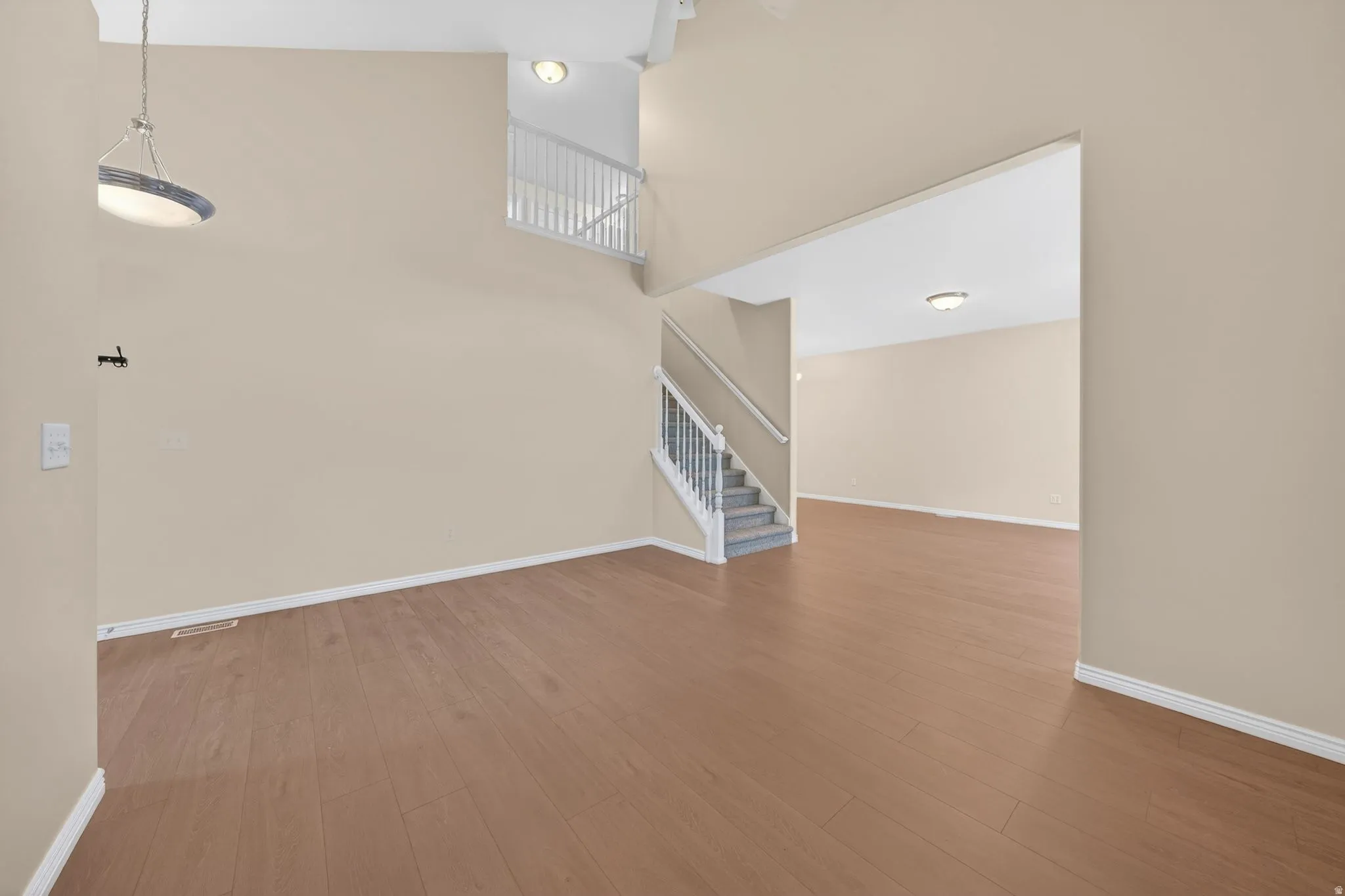 Open concept interior featuring wood-finish flooring, neutral wall tones, and white trim