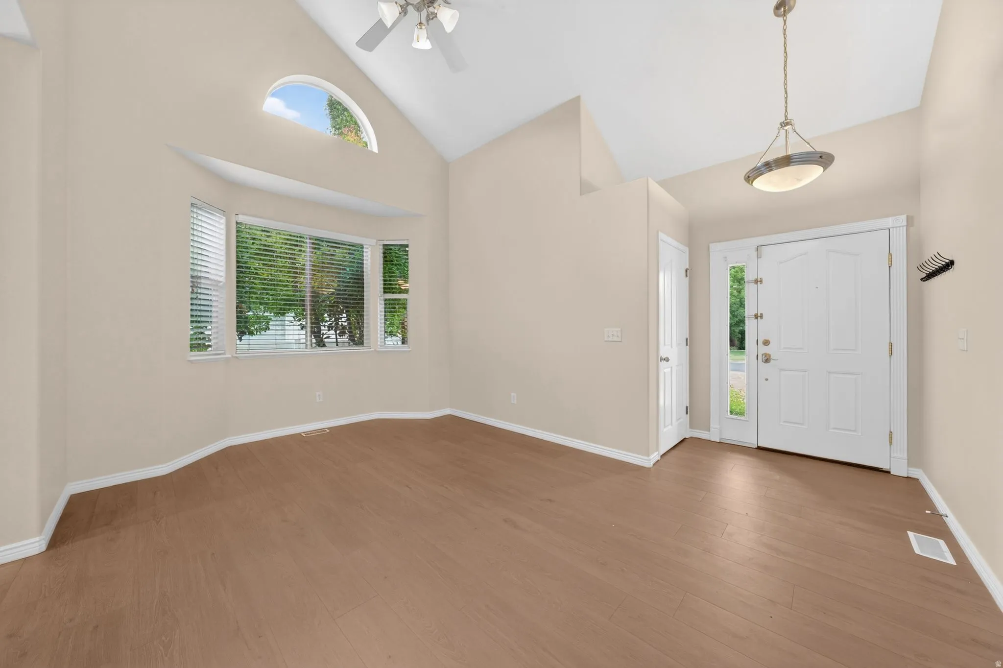 Vaulted ceilings featuring a ceiling fan and a pendant light fixture