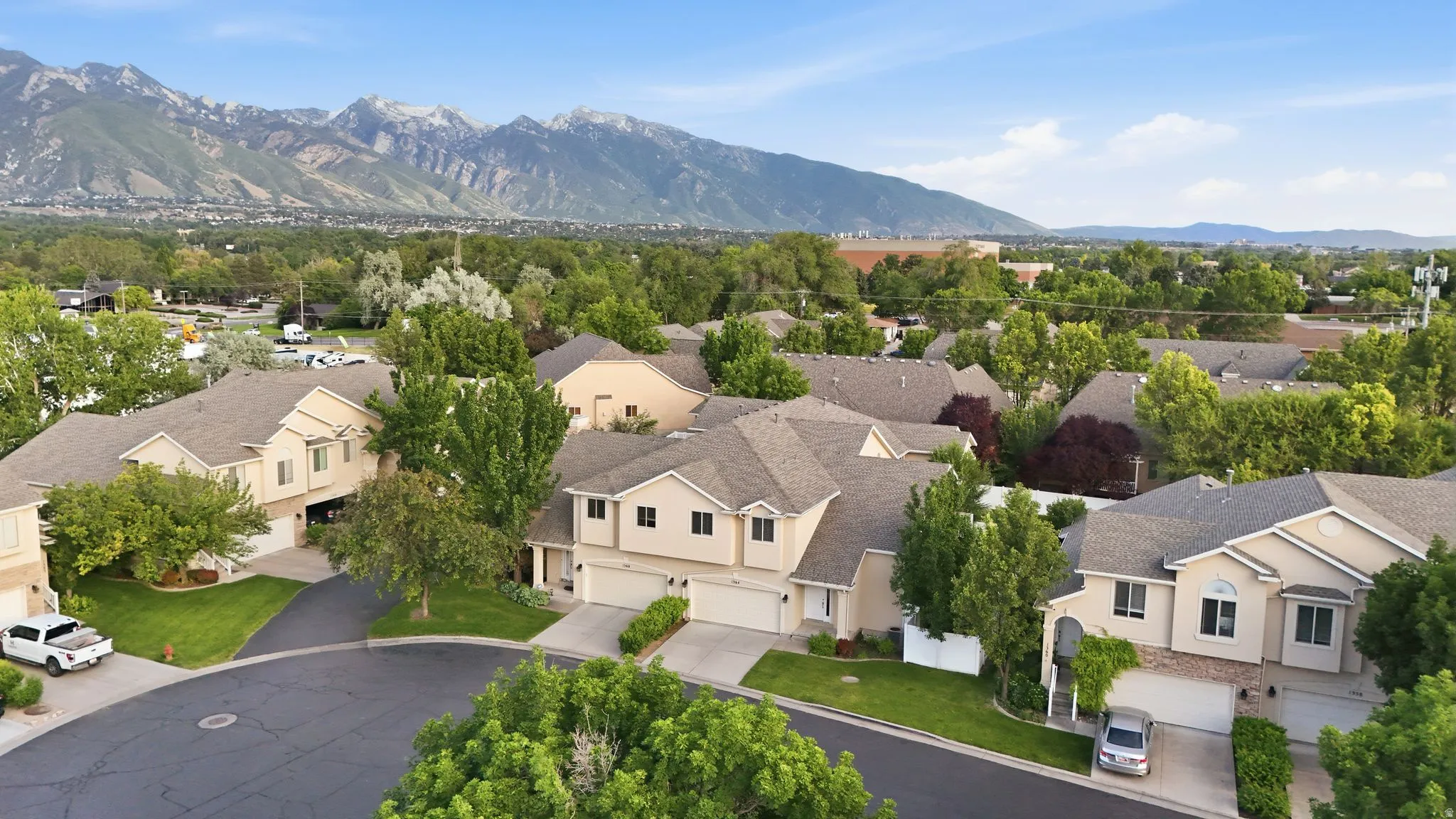 Residential neighborhood featuring a cul-de-sac, mature trees, and mountain backdrop