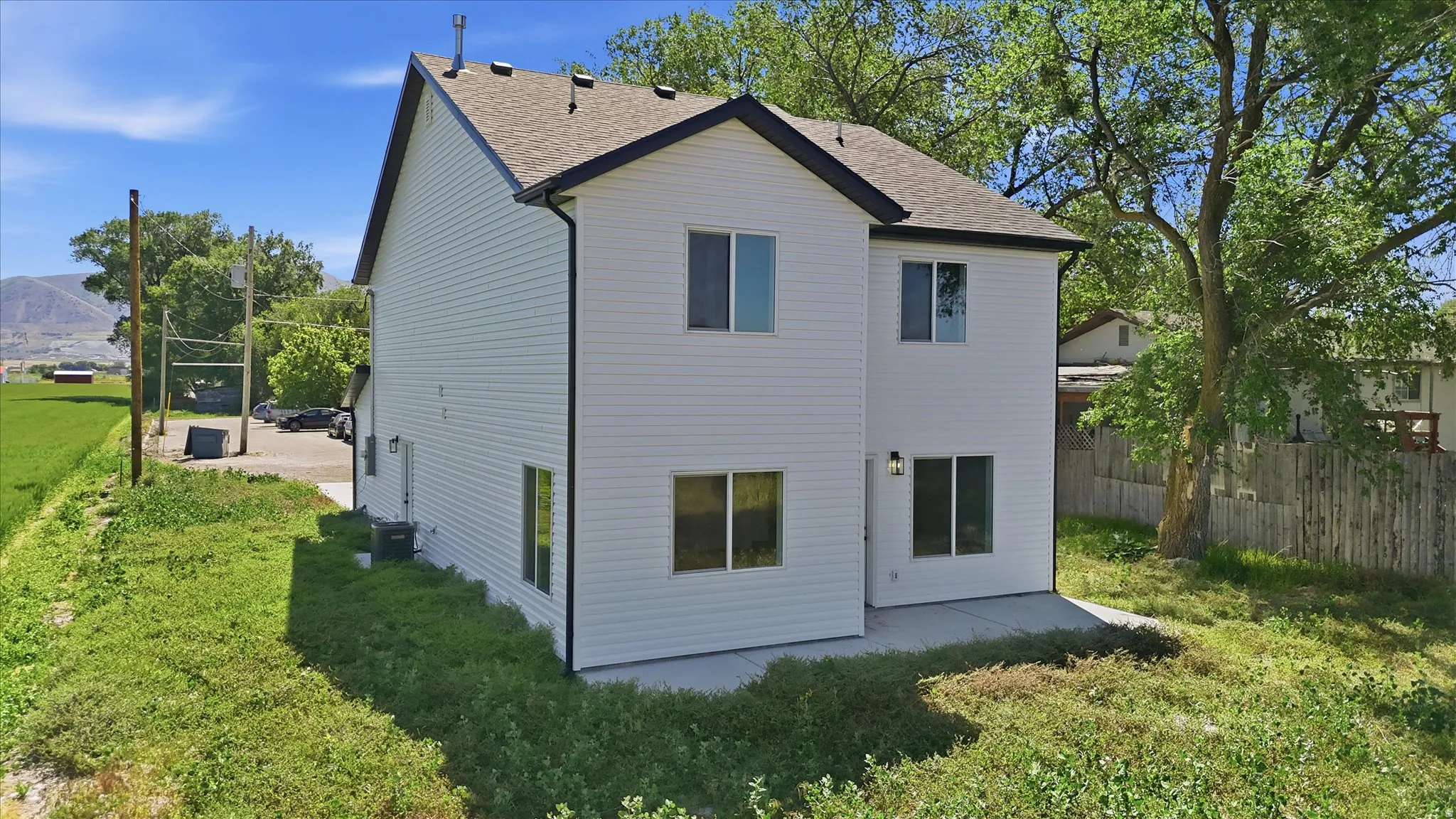Newly constructed two-story residence featuring white siding and dark trim