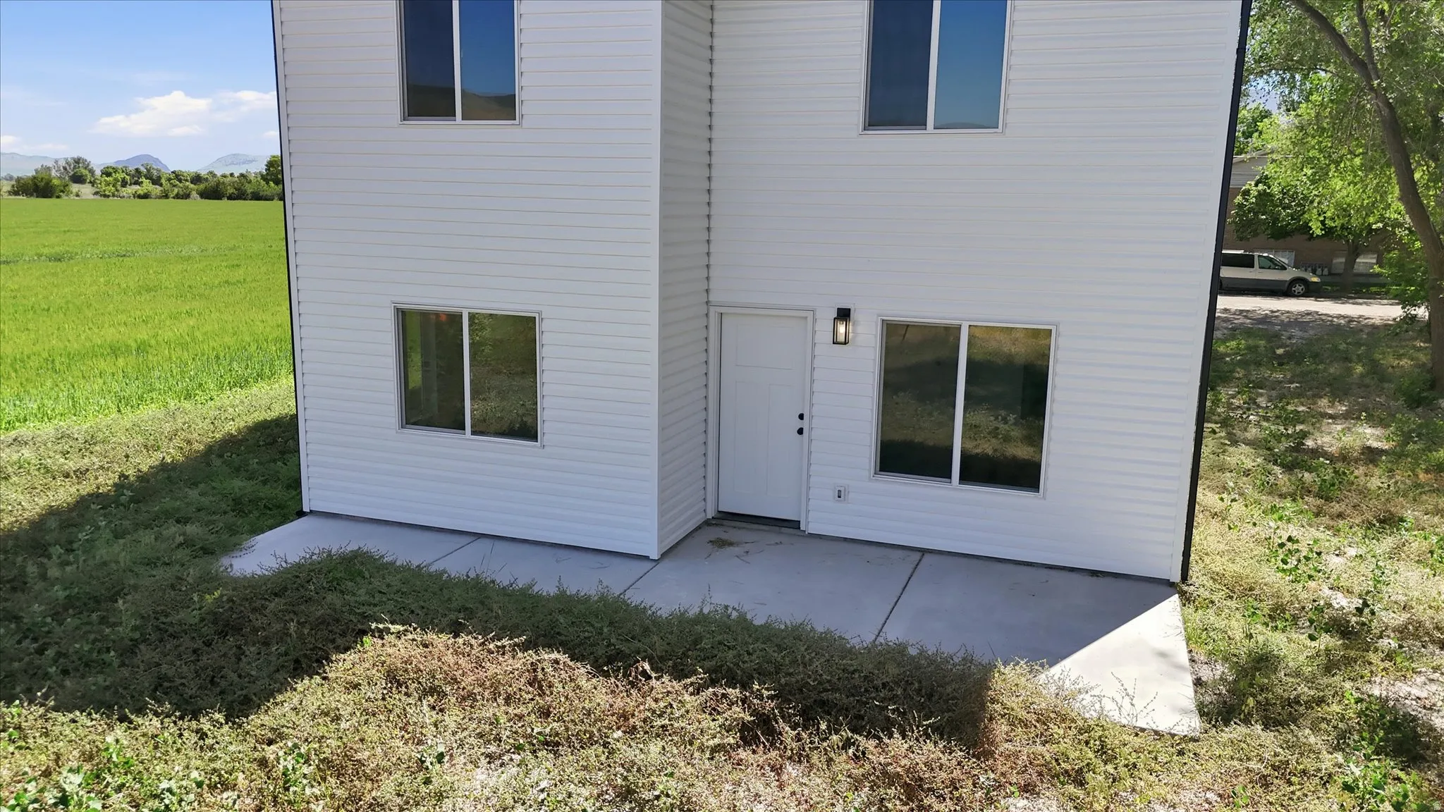 Two-story white siding exterior with multiple windows and a private entrance