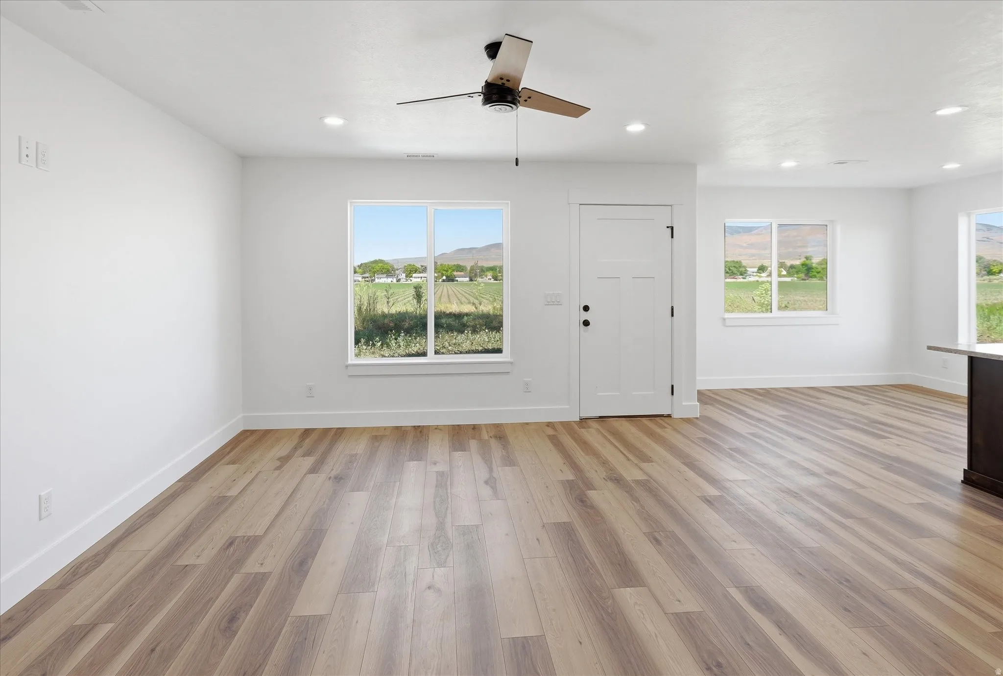 Spacious interior featuring wood-finish flooring, recessed lighting, and a contemporary ceiling fan