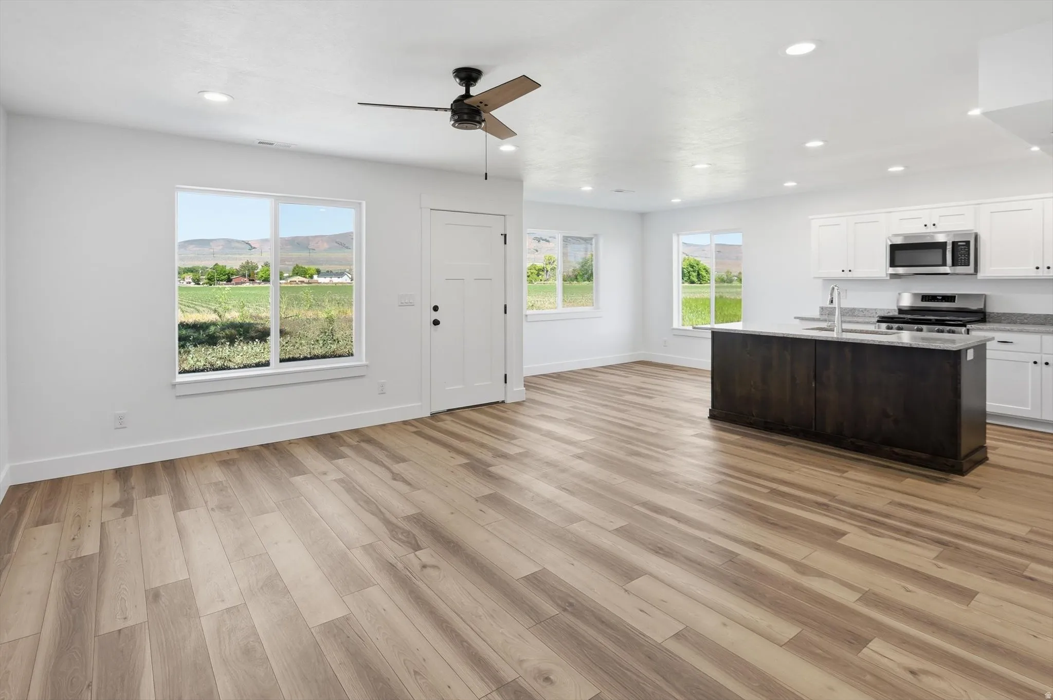 Open concept living area featuring wood-finish flooring, recessed lighting, and a ceiling fan
