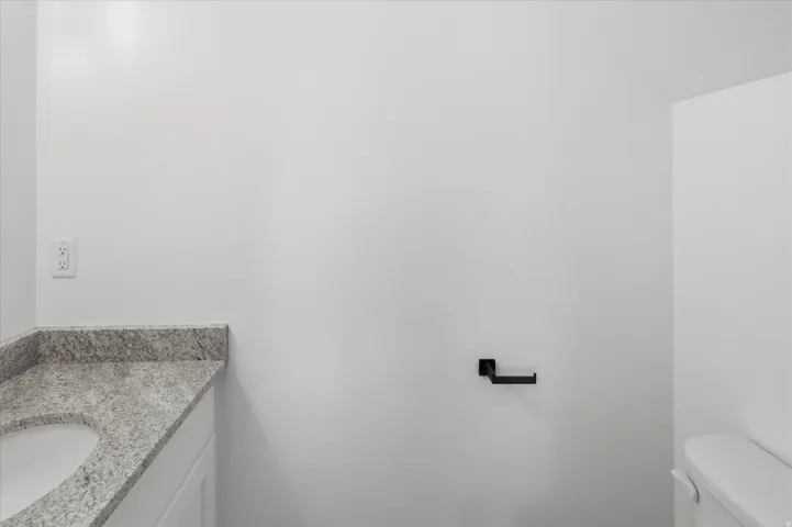 White vanity with a speckled countertop and an integrated oval sink